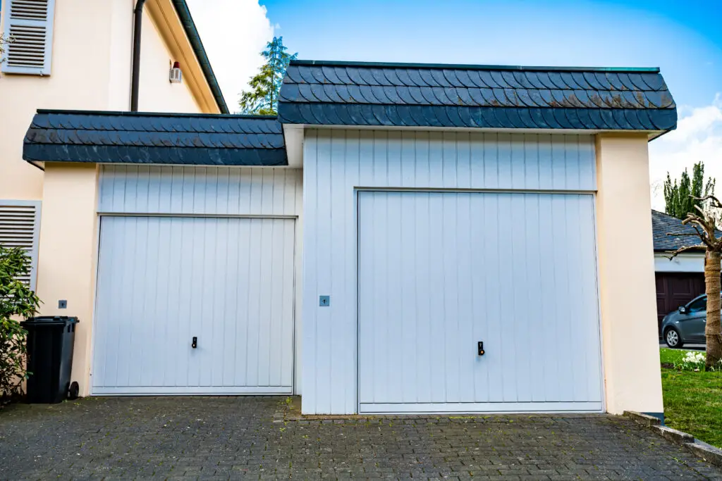 Two white garage doors with a blue roof.